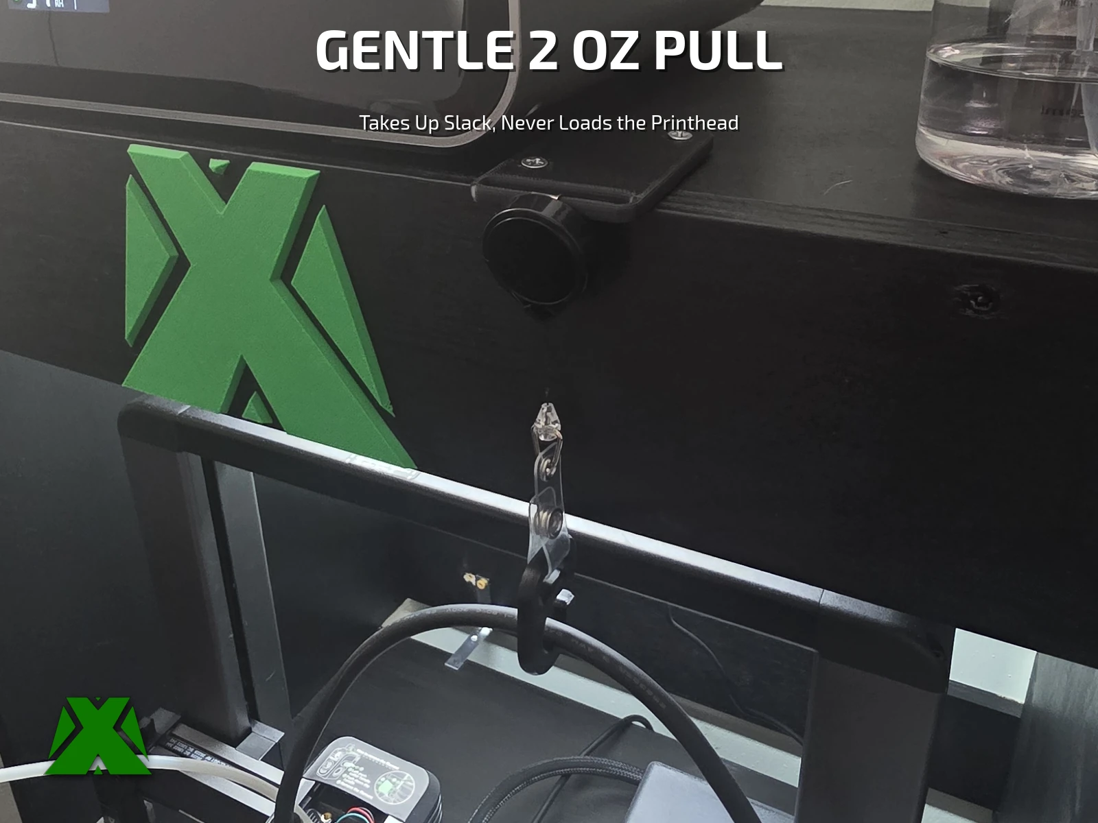 The whole setup on the printer: the reel mounted under the shelf, its clear strap running down to the hook, holding the cable up off the gantry