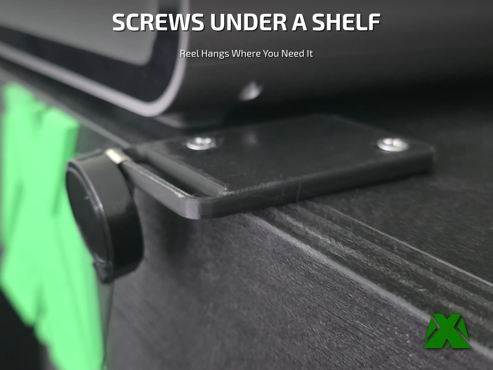 The plate screwed flat to the underside of a shelf through both countersunk holes, with the badge reel hanging from its front edge