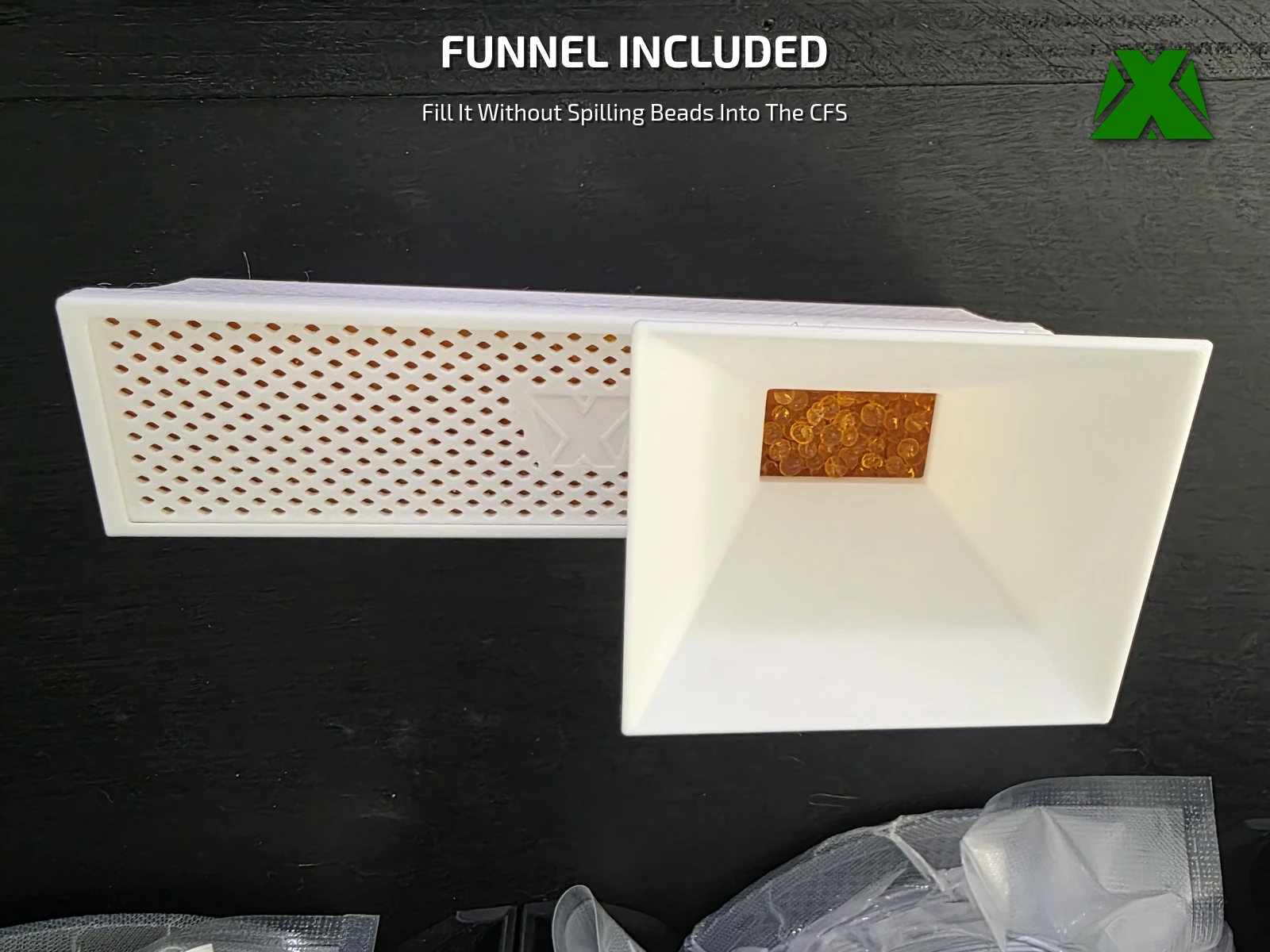 The printed funnel resting on a tray, guiding beads in without spilling them