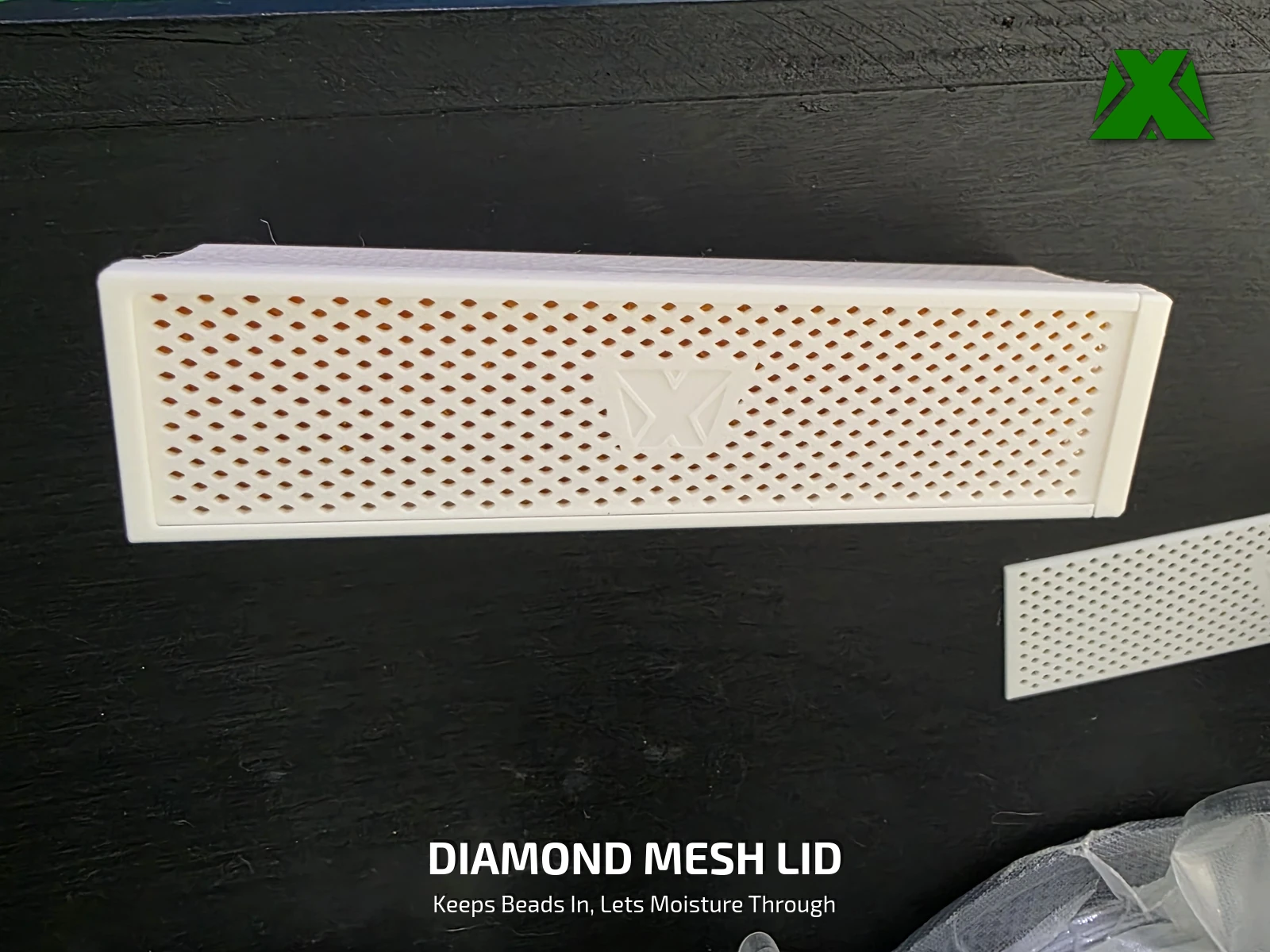 The diamond-mesh lid seen from above, with the embossed MakerX mark in the middle