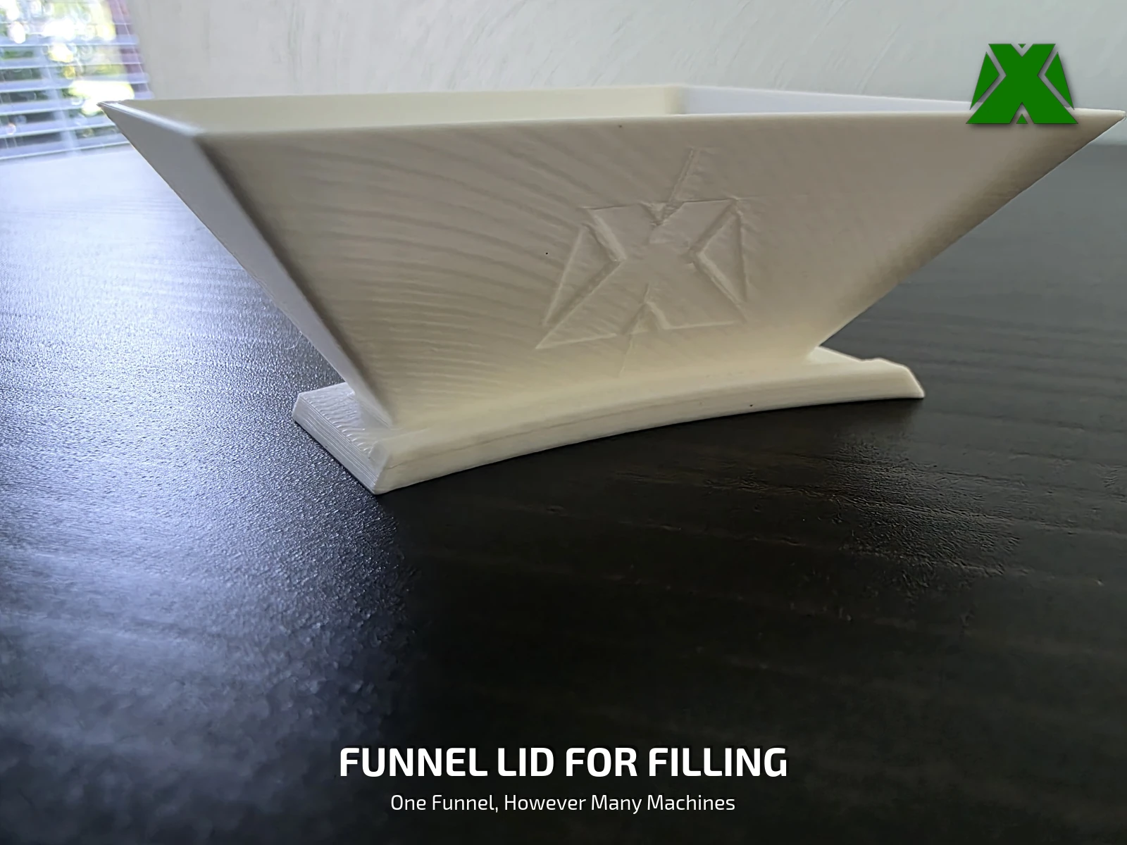 The printed funnel lid seen from the side, with the debossed MakerX mark across its face
