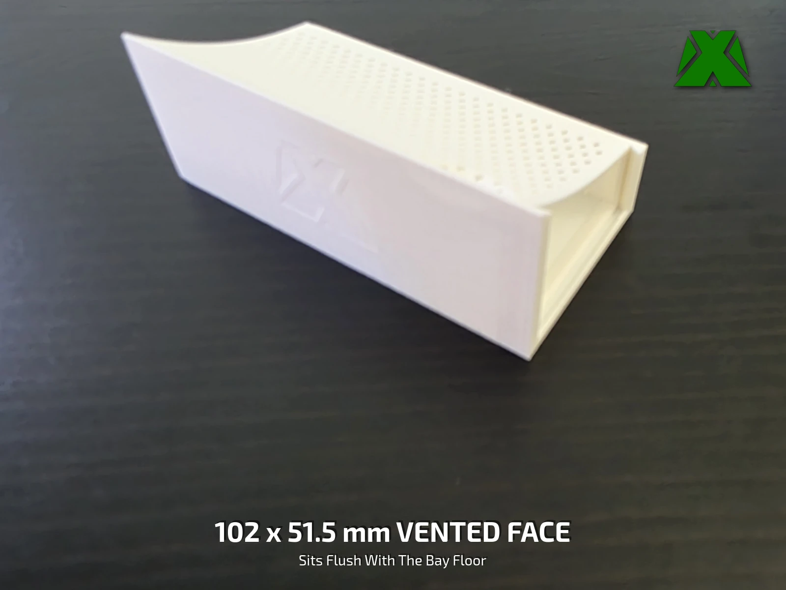 One tray on a dark desk, its perforated face and the scalloped finger recess along the top edge in view