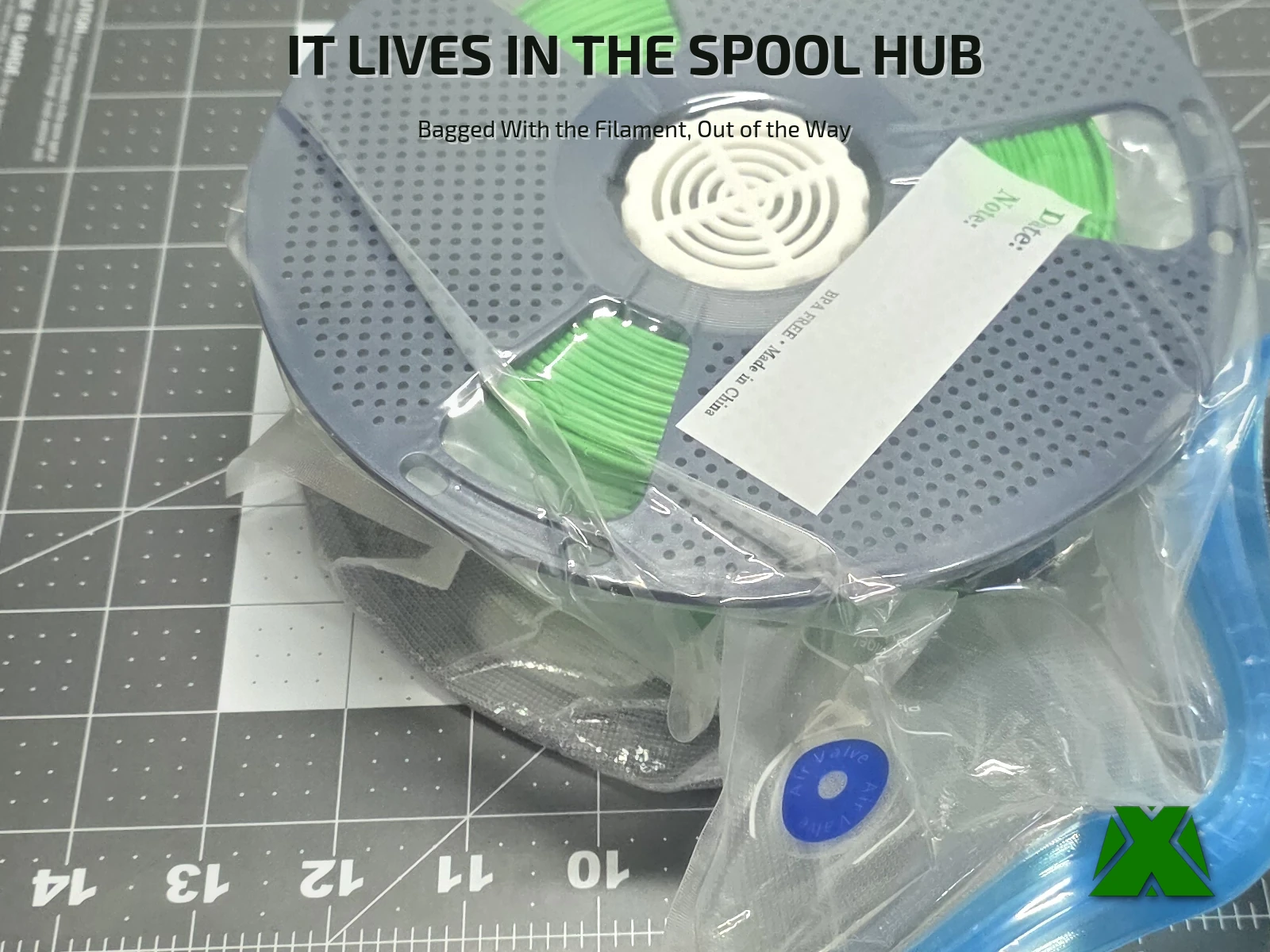 The container seated in the center hub of a green filament spool, the whole spool sealed inside a vacuum bag and lying flat