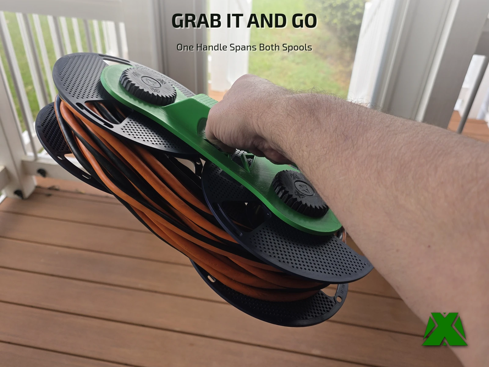 A hand carrying the loaded spooler by its green handle on a deck