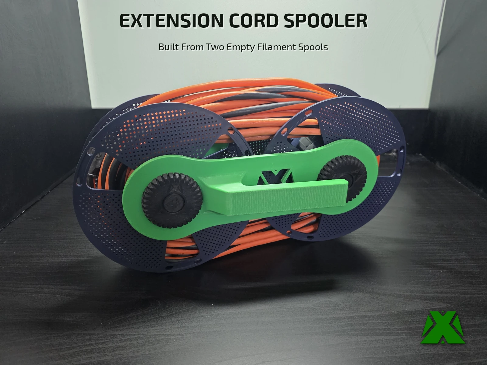 An orange extension cord wound around two navy filament spools held side by side by a green handle plate and black knurled nuts