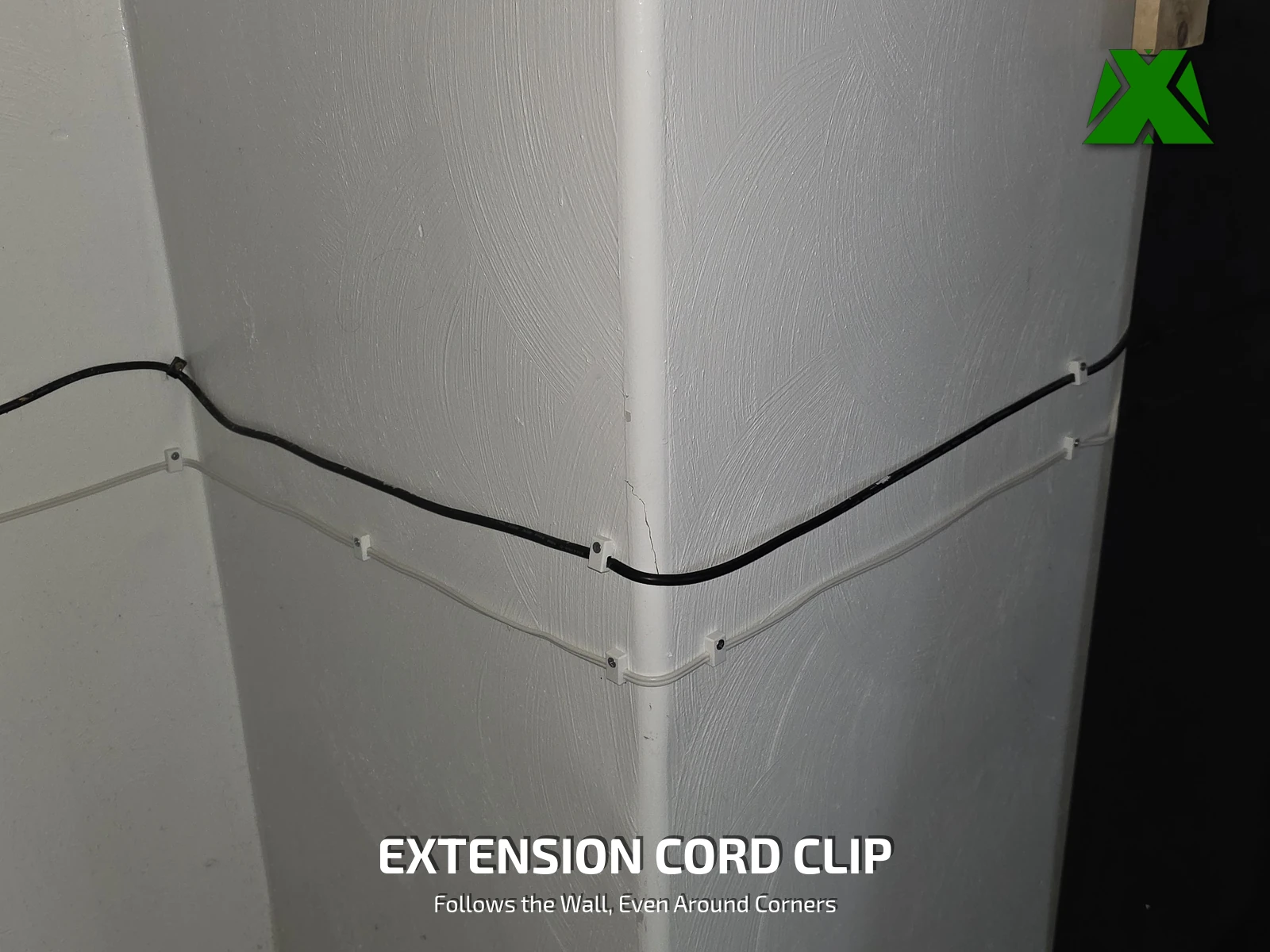 White printed clips carrying a black extension cord and a white cord around an inside wall corner, the cords tracking straight instead of bowing away