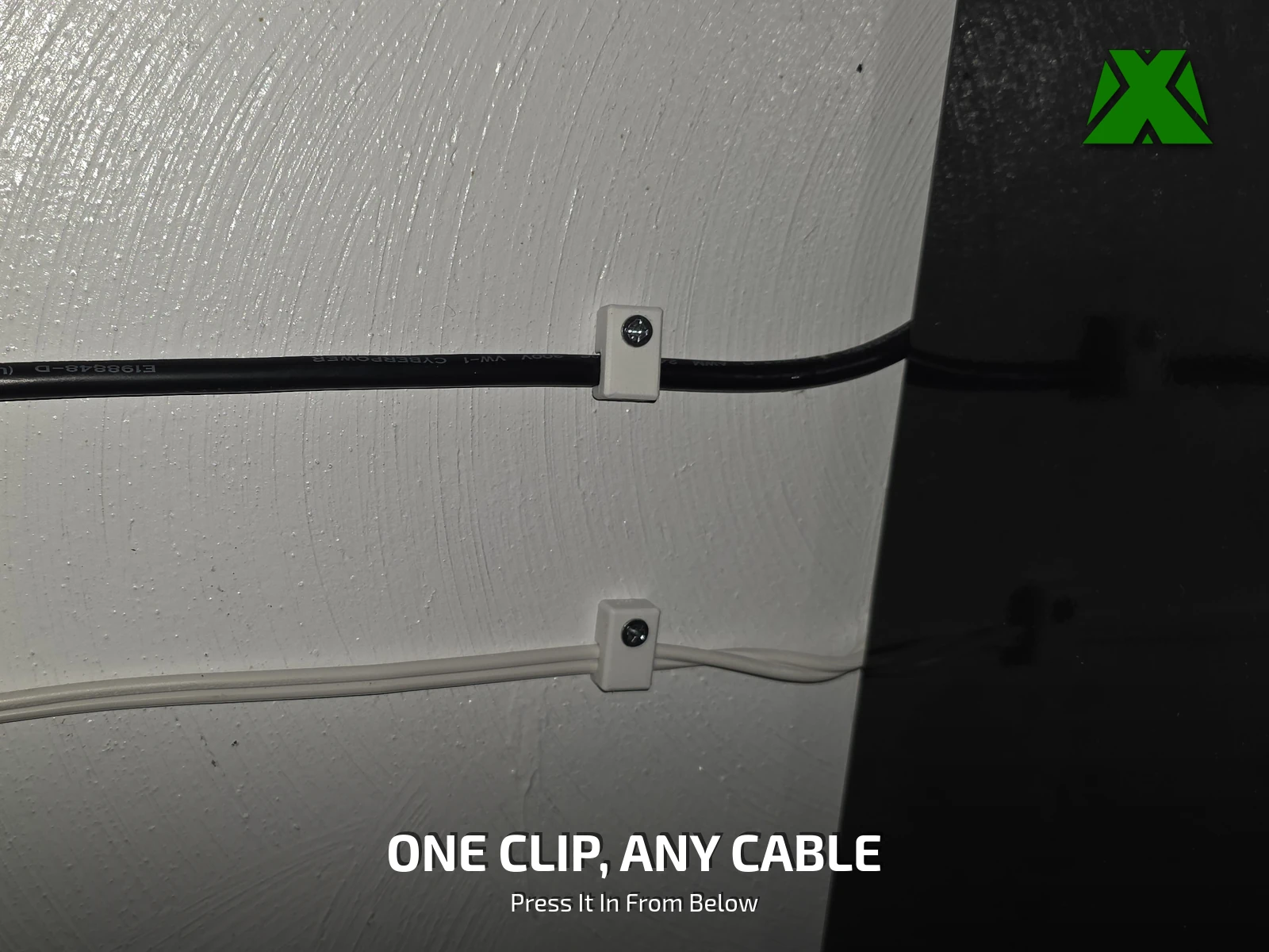Two clips screwed to a white wall, one holding a heavy black extension cord and the other a thin white cable