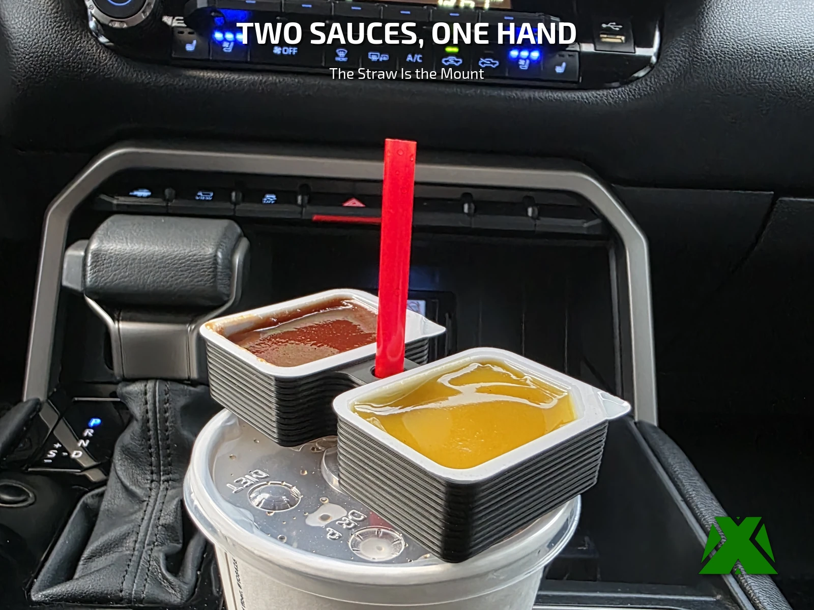 The black holder riding on a drink cup in a car console, a barbecue sauce cup in one bay and honey mustard in the other, with a red straw up through the center port
