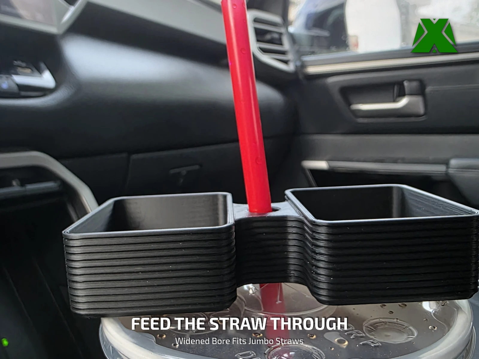 The empty holder settled on a cup lid with a red straw running up through the center port, showing how the straw alone carries it