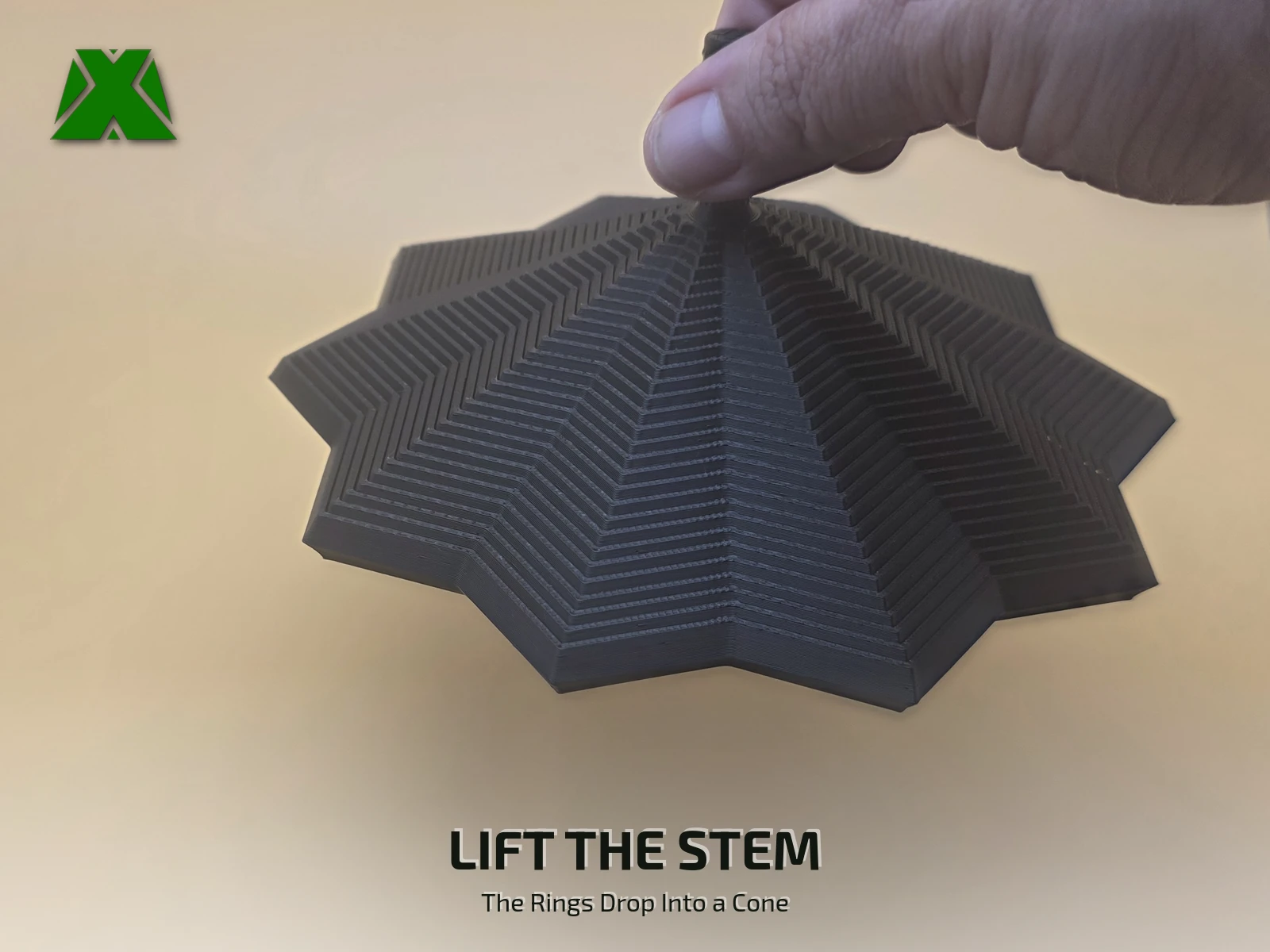 Fingers lifting the fidget ten-point star by its textured stem, the 28 rings dropping below into a cone