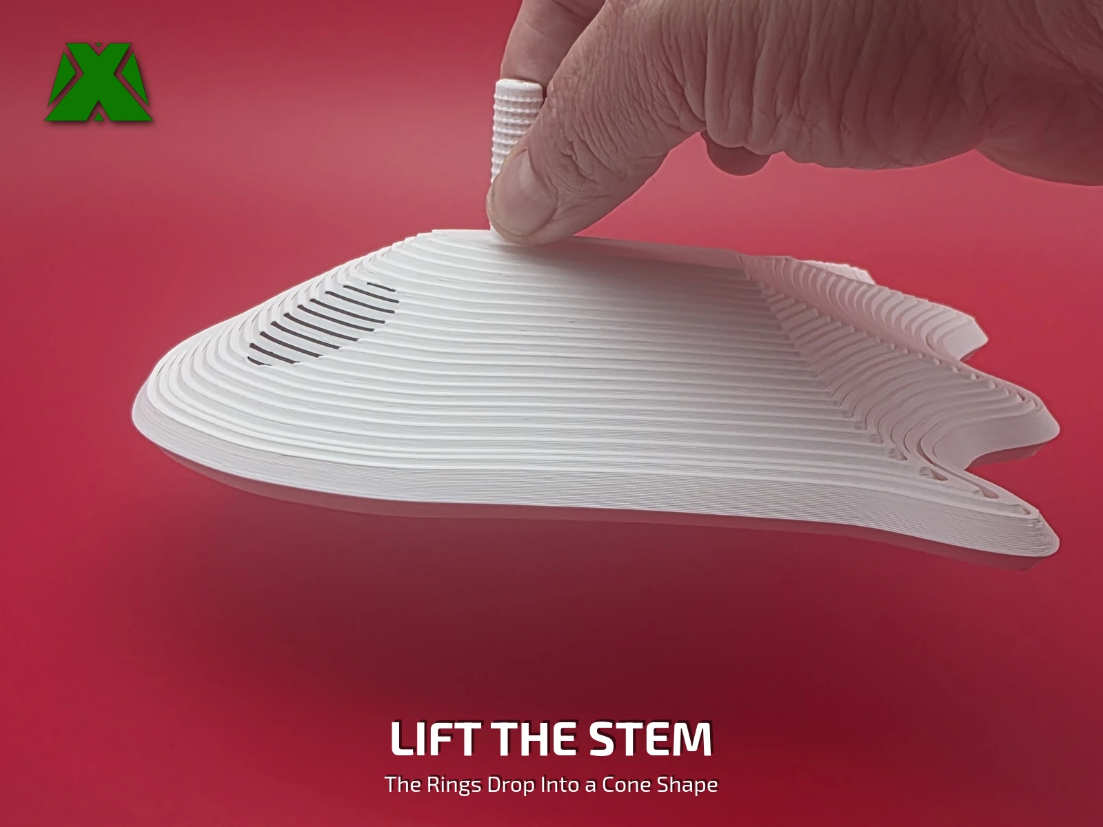 Fingers lifting the fidget ghost by its textured stem, the white rings stepping down below into a cone-like shape