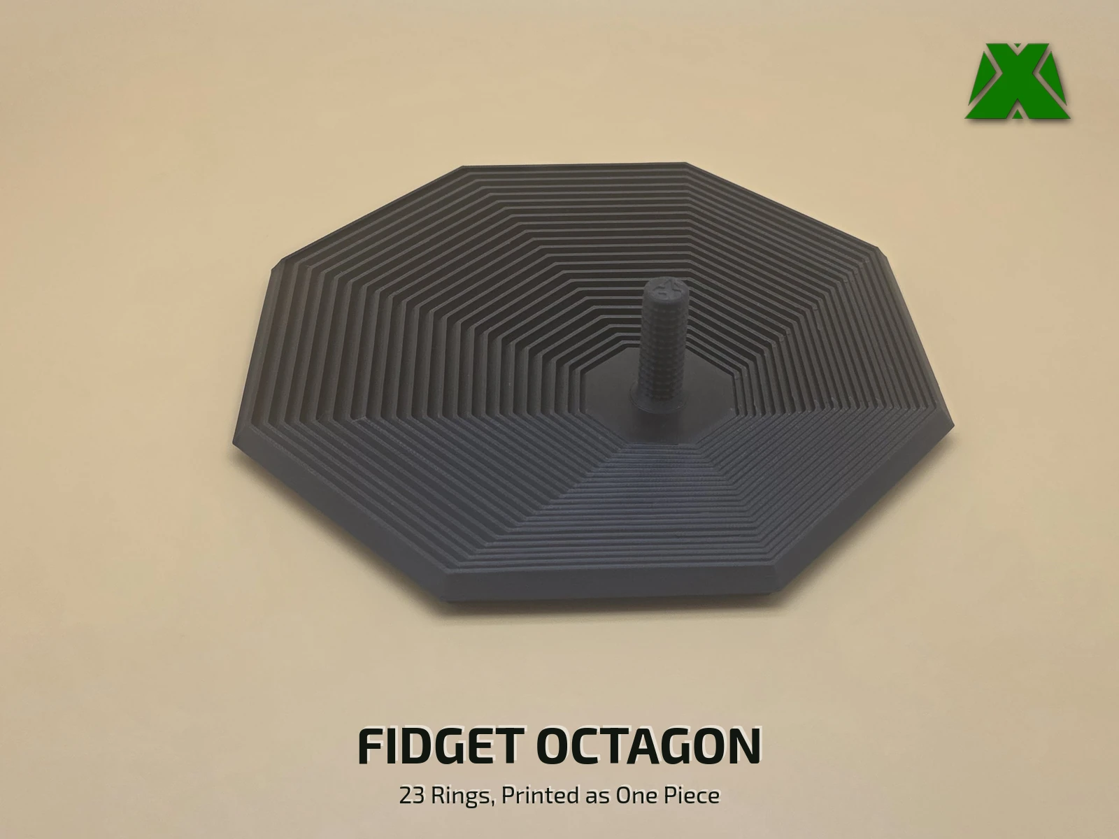 A black print-in-place fidget octagon lying flat on a tan backdrop, its 23 nested eight-sided rings stepping out from a short textured stem