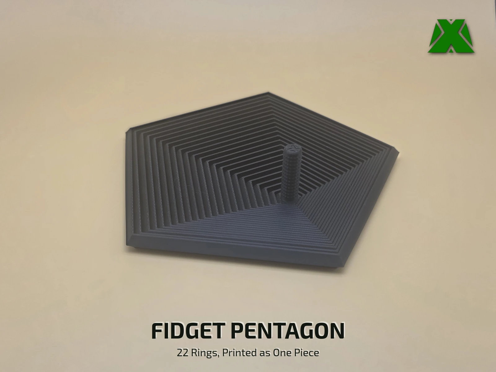 A black print-in-place fidget pentagon lying flat on a tan backdrop, its 22 nested five-sided rings stepping out from a short textured stem
