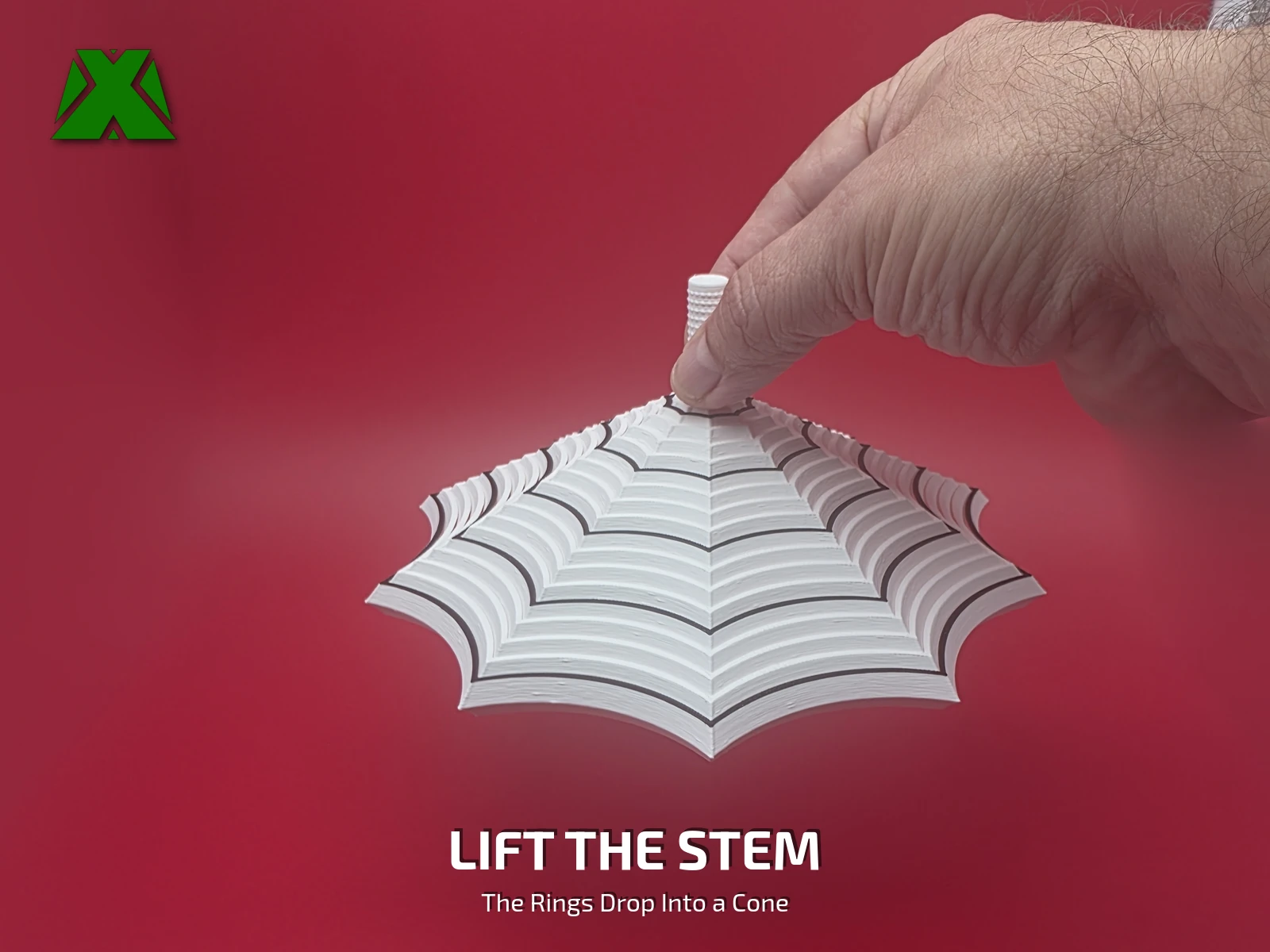 Fingers lifting the fidget spider web by its textured stem, the rings hanging below in a scalloped cone