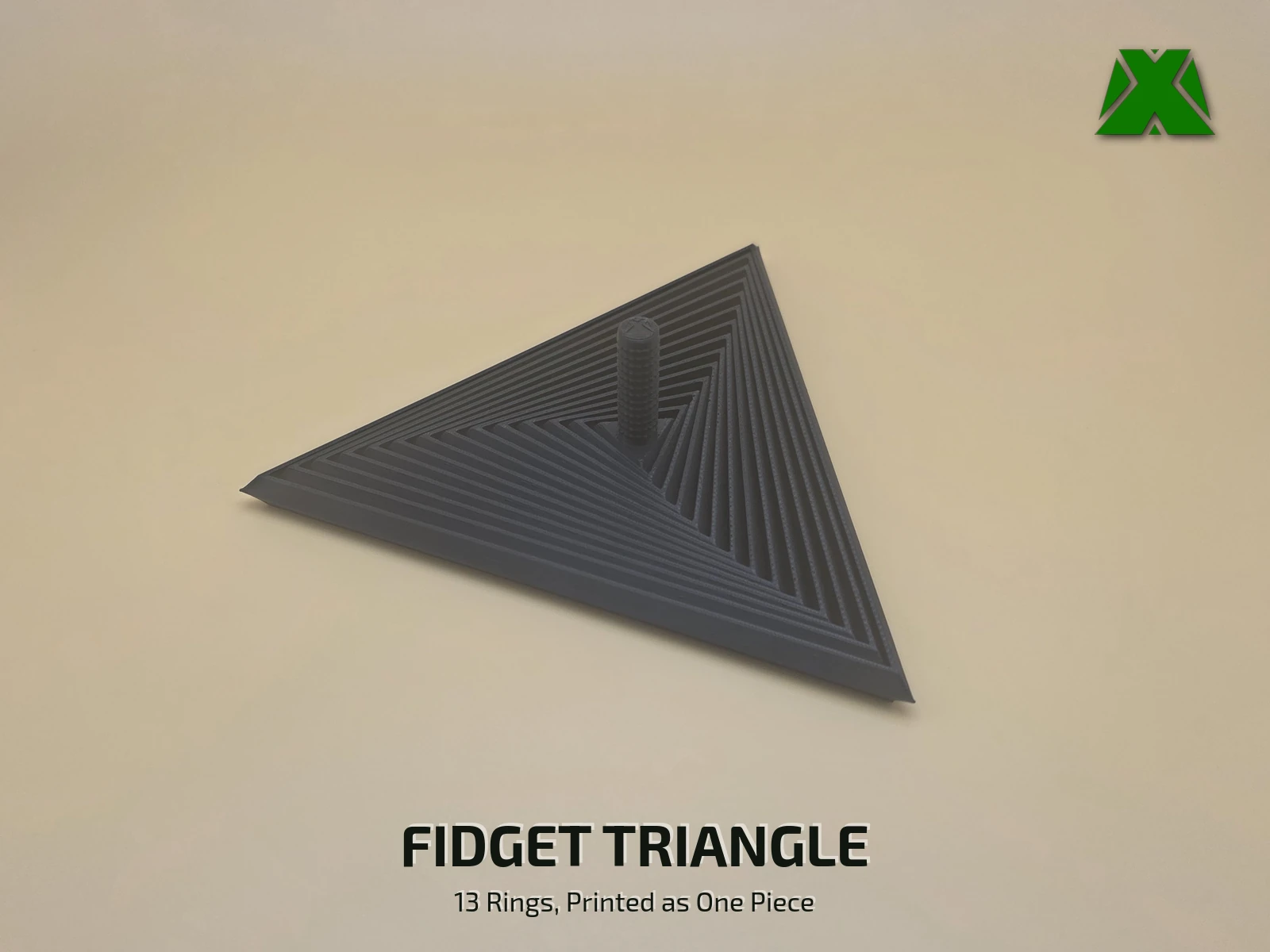 A black print-in-place fidget triangle lying flat on a tan backdrop, its 13 nested triangular rings stepping out from a short textured stem
