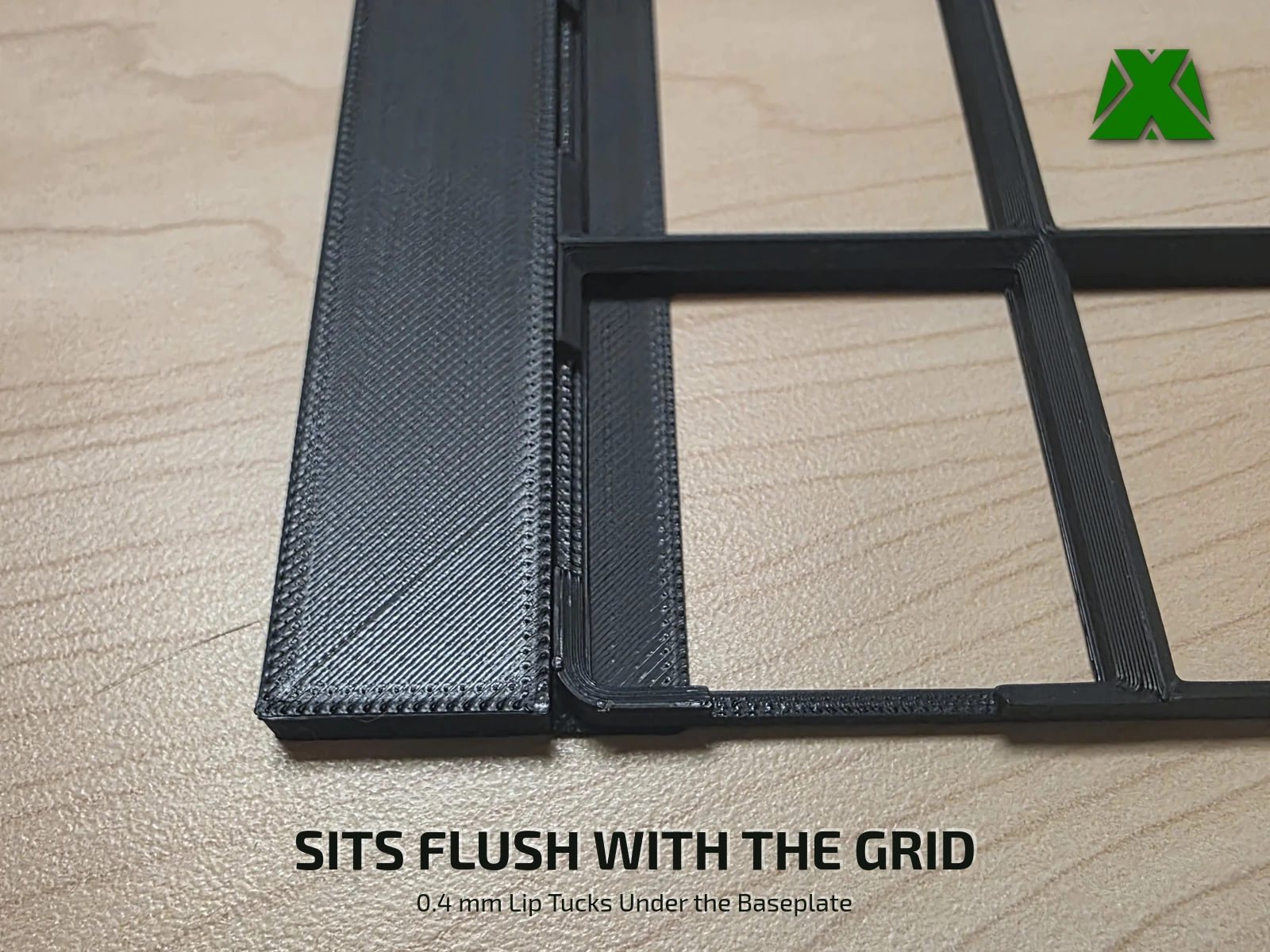 A spacer strip beside a baseplate edge, its thin lip tucked under the grid so the two tops sit level