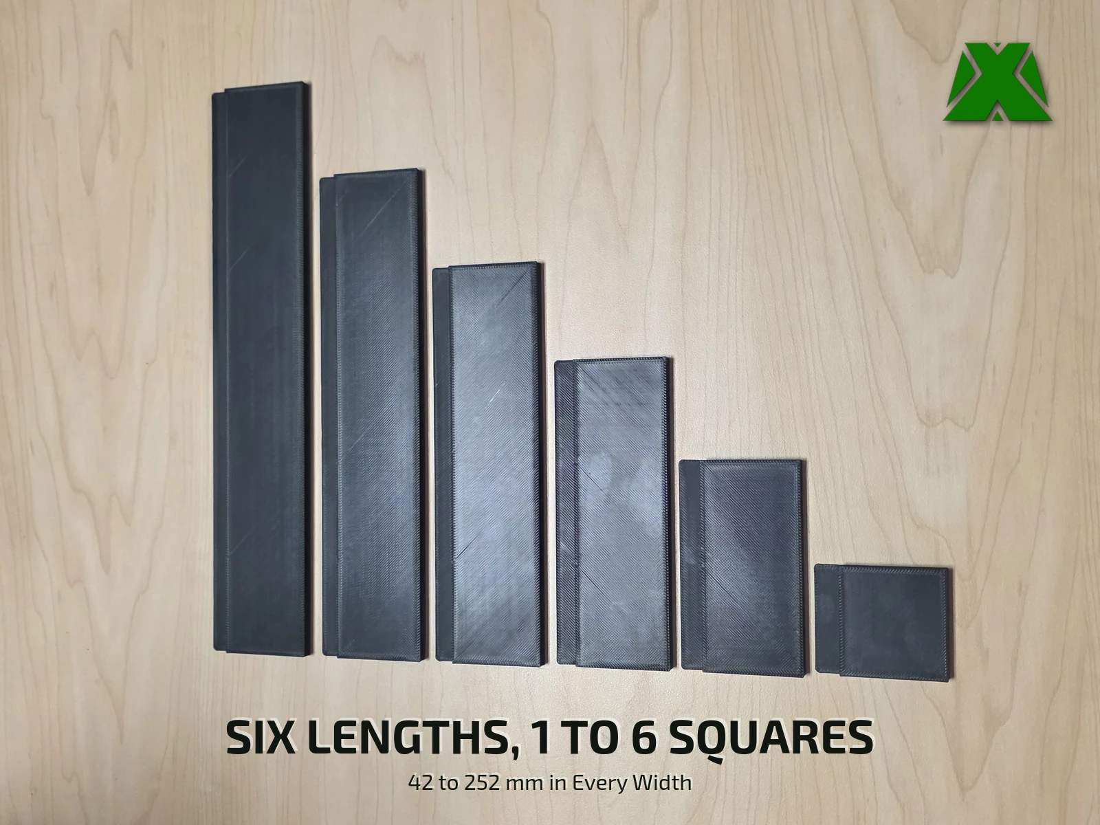 Six black spacers of increasing length laid side by side on a wooden table