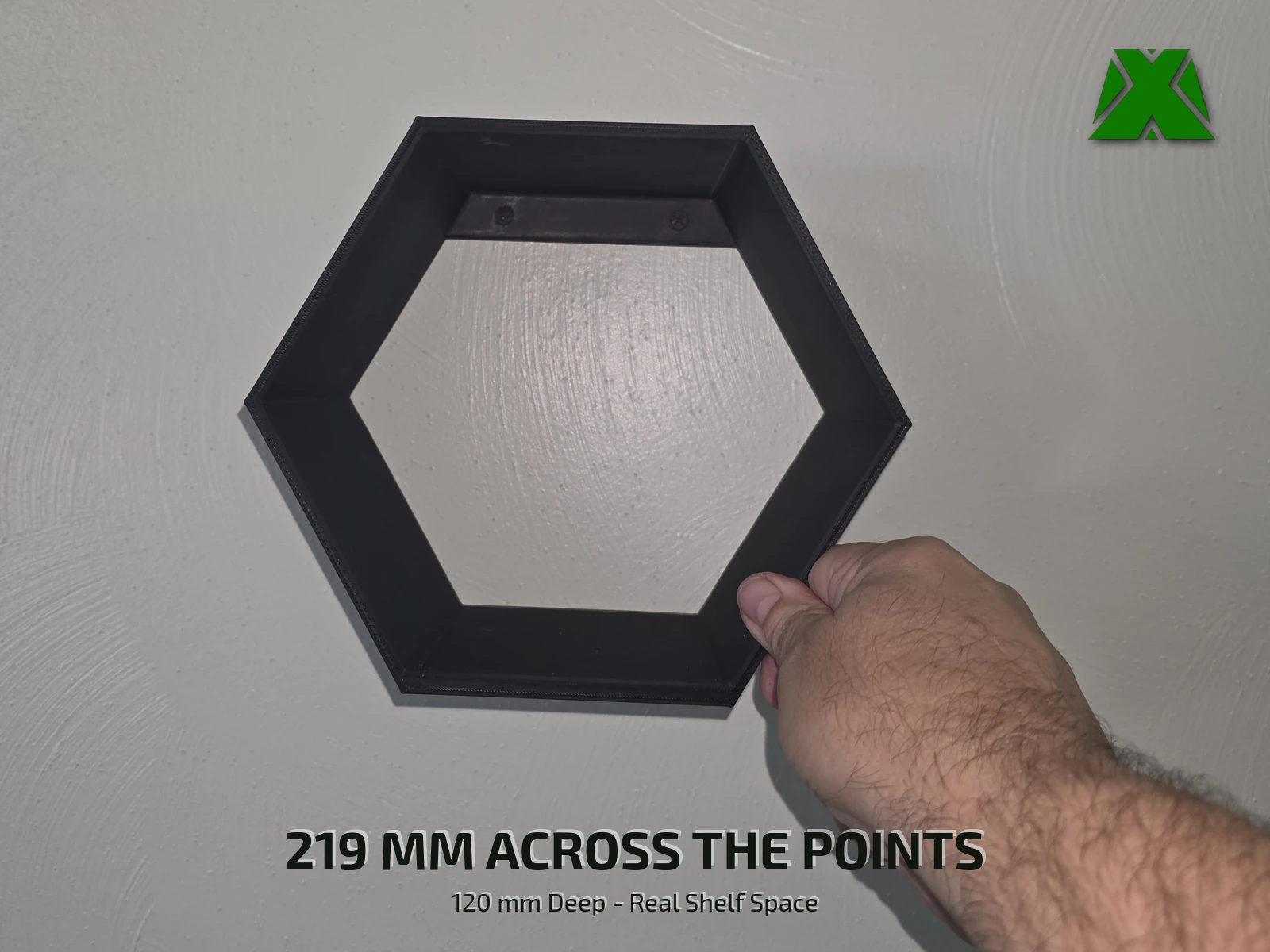 A hand gripping the lower right edge of the mounted shelf, giving the scale of the hexagon