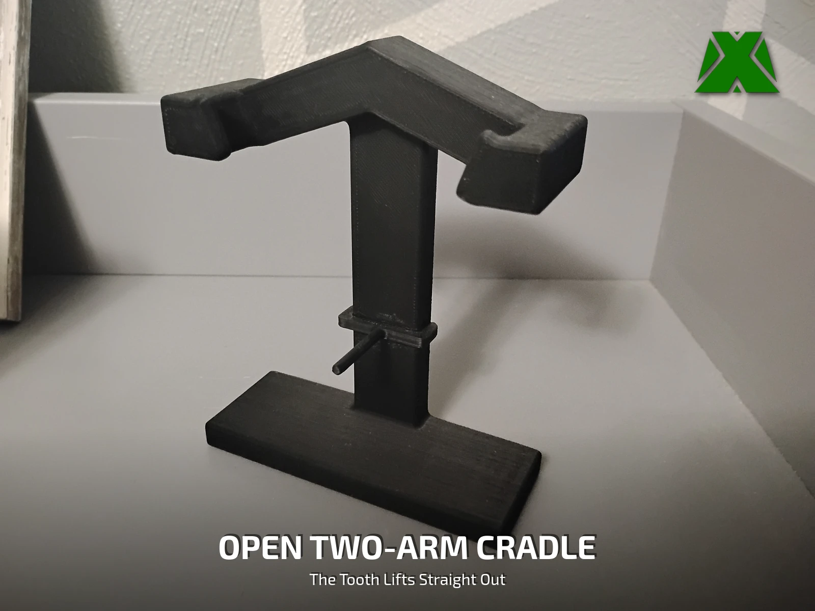 The empty stand printed in black PLA, showing the two open cradle arms and the counterweighted upright on its flat base