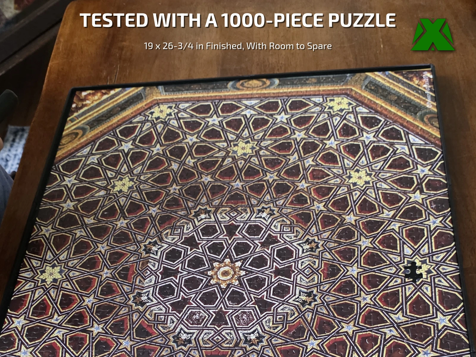 A finished 1000-piece puzzle of an ornate star-patterned ceiling sitting inside the tray on a wooden table