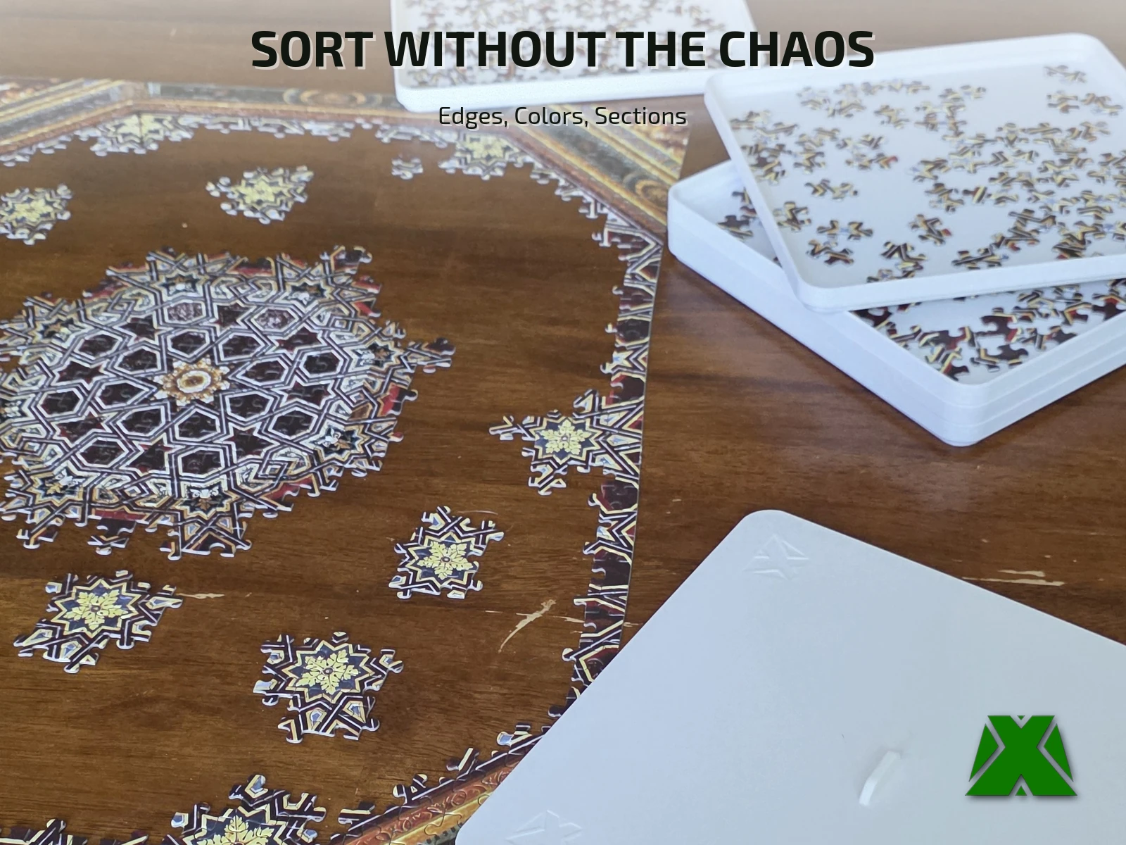 Trays beside a puzzle in progress, each one holding pieces grouped by color and section