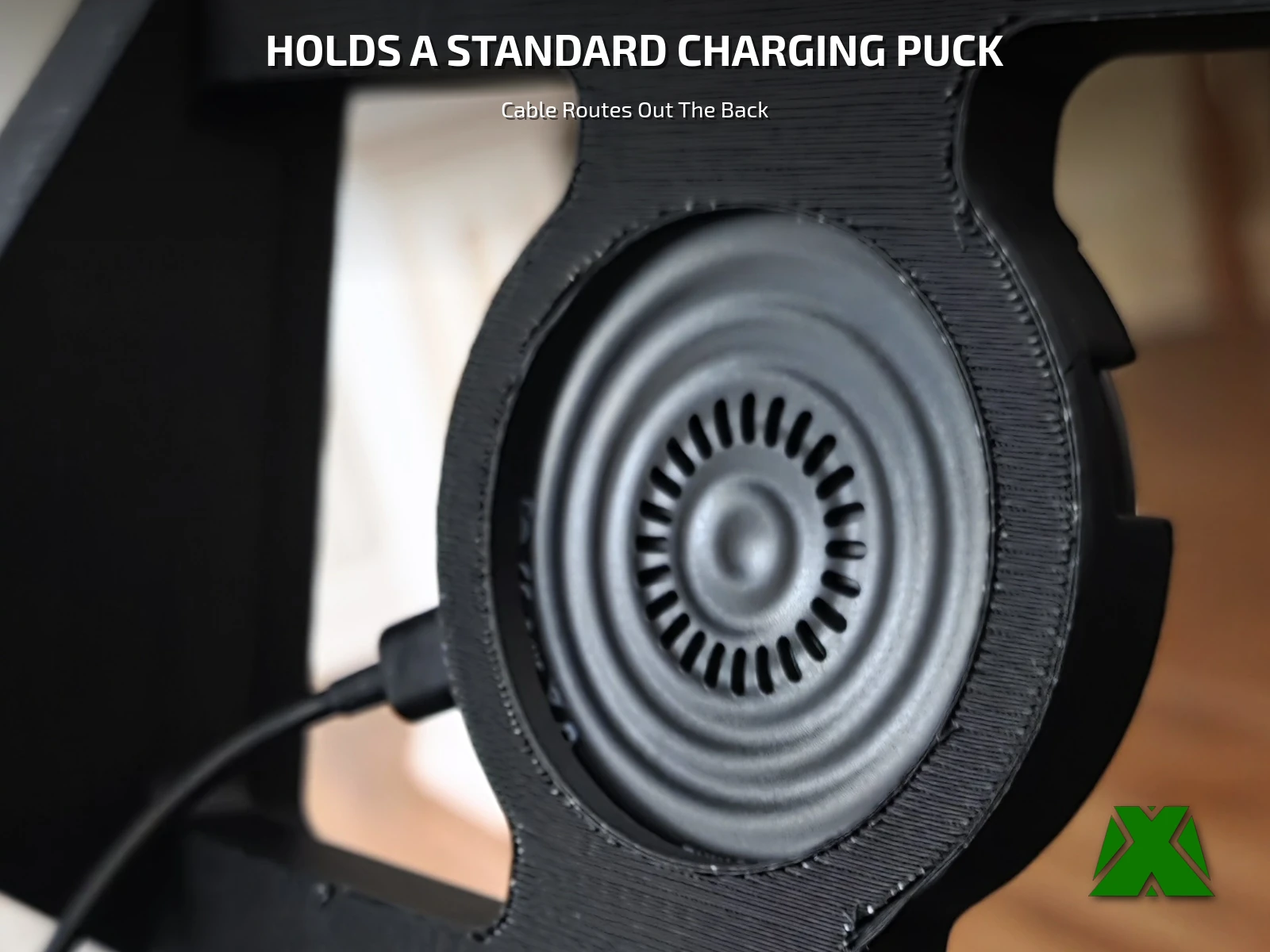 A close view of the stand's recess holding a round charging puck, cable exiting behind