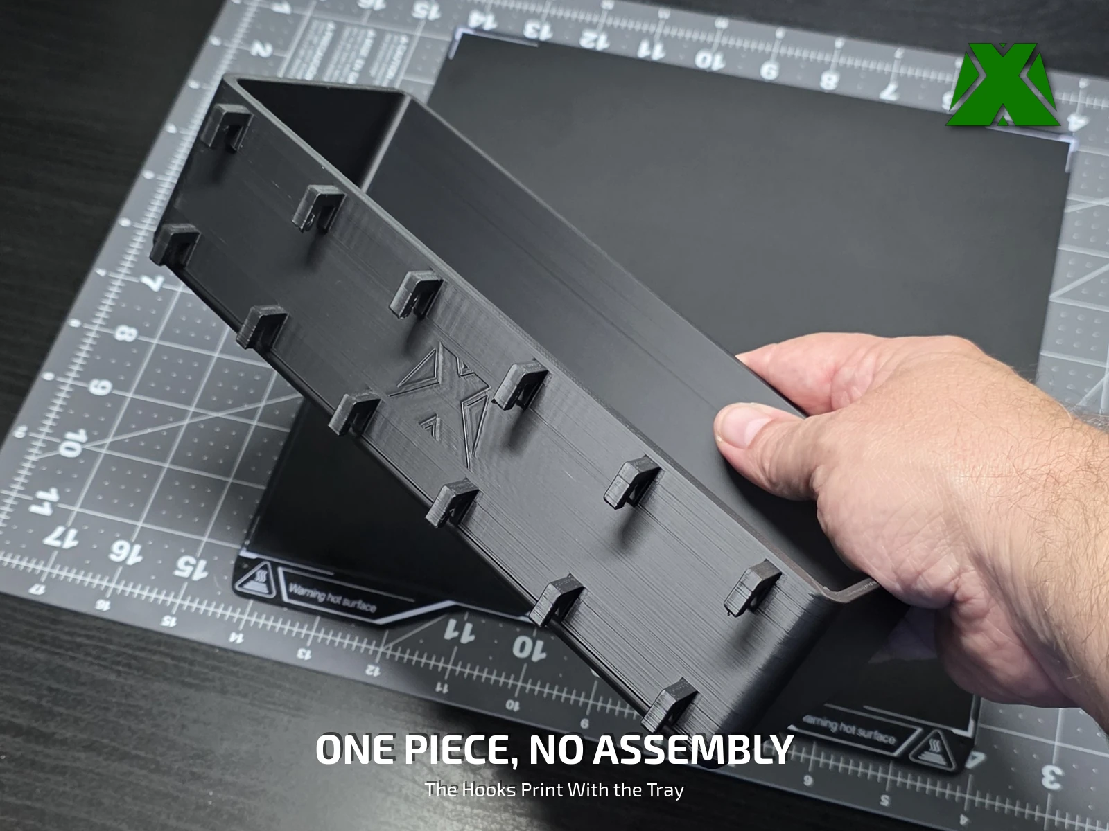 A hand lifting the finished tray, showing it is a single printed part with the hooks attached