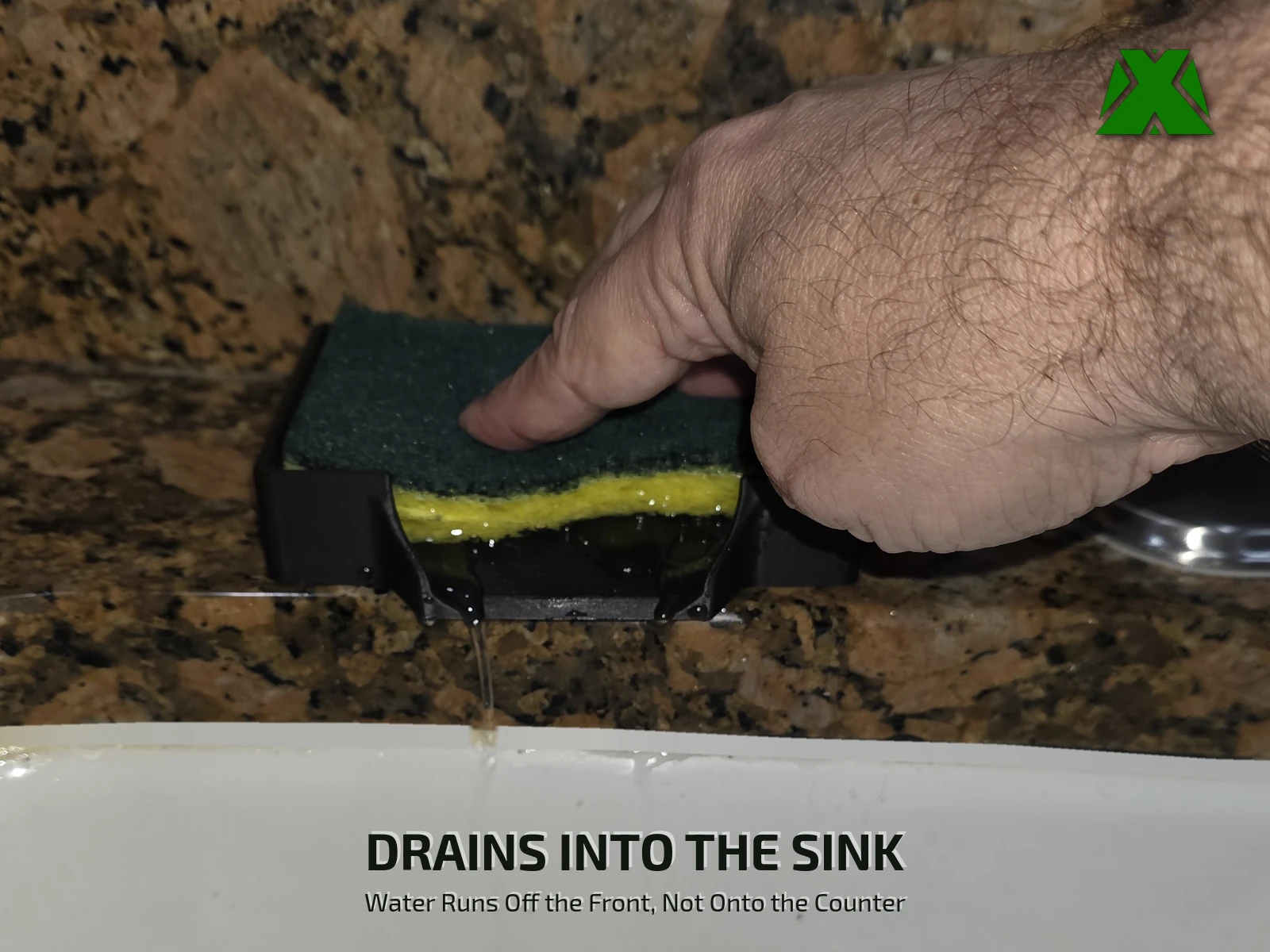A hand pressing a sponge down in the tray while a stream of water runs out of the drain mouth and falls into the sink
