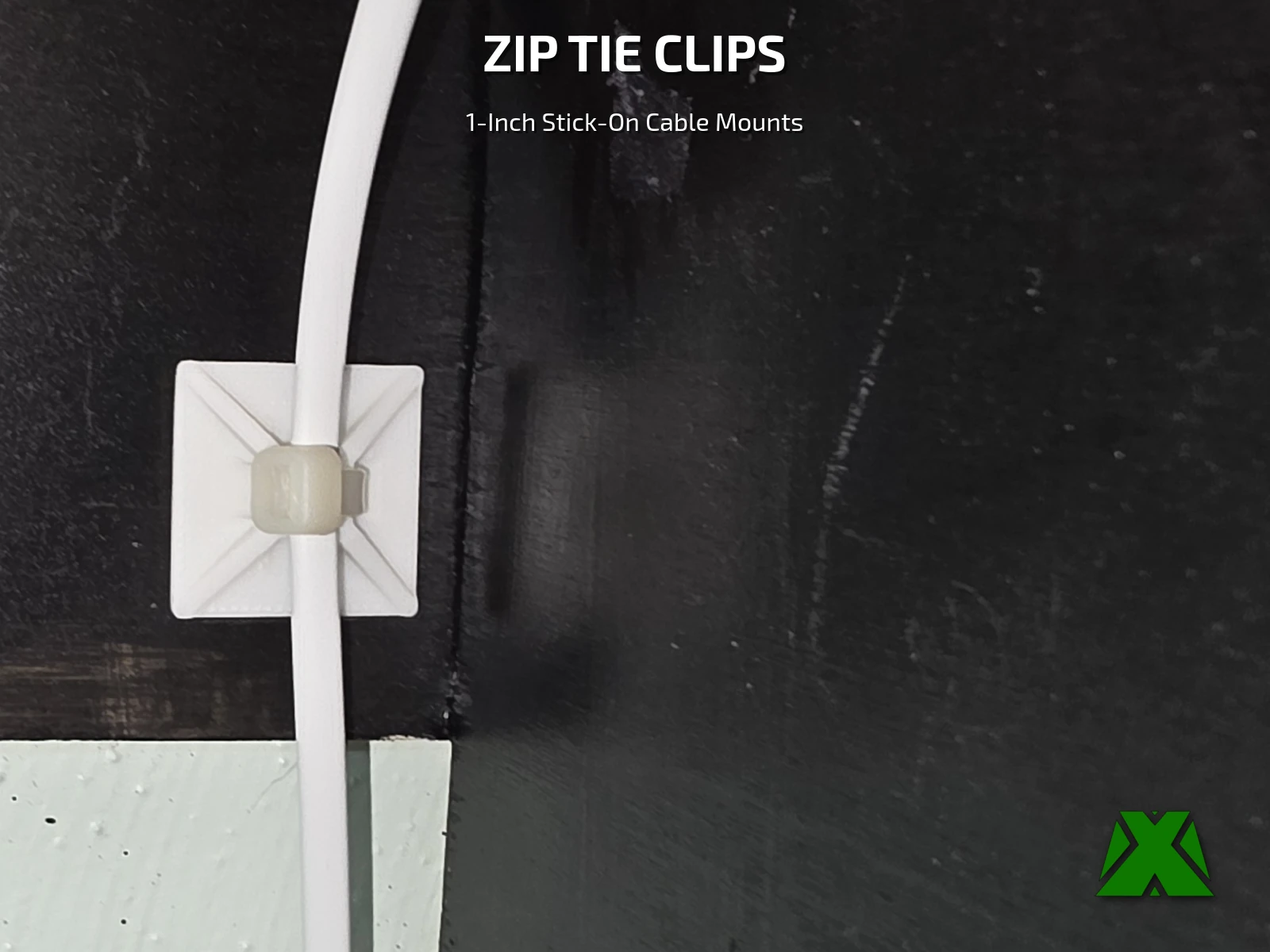 A white square clip stuck to a black panel, with a zip tie holding a flat white cable against it