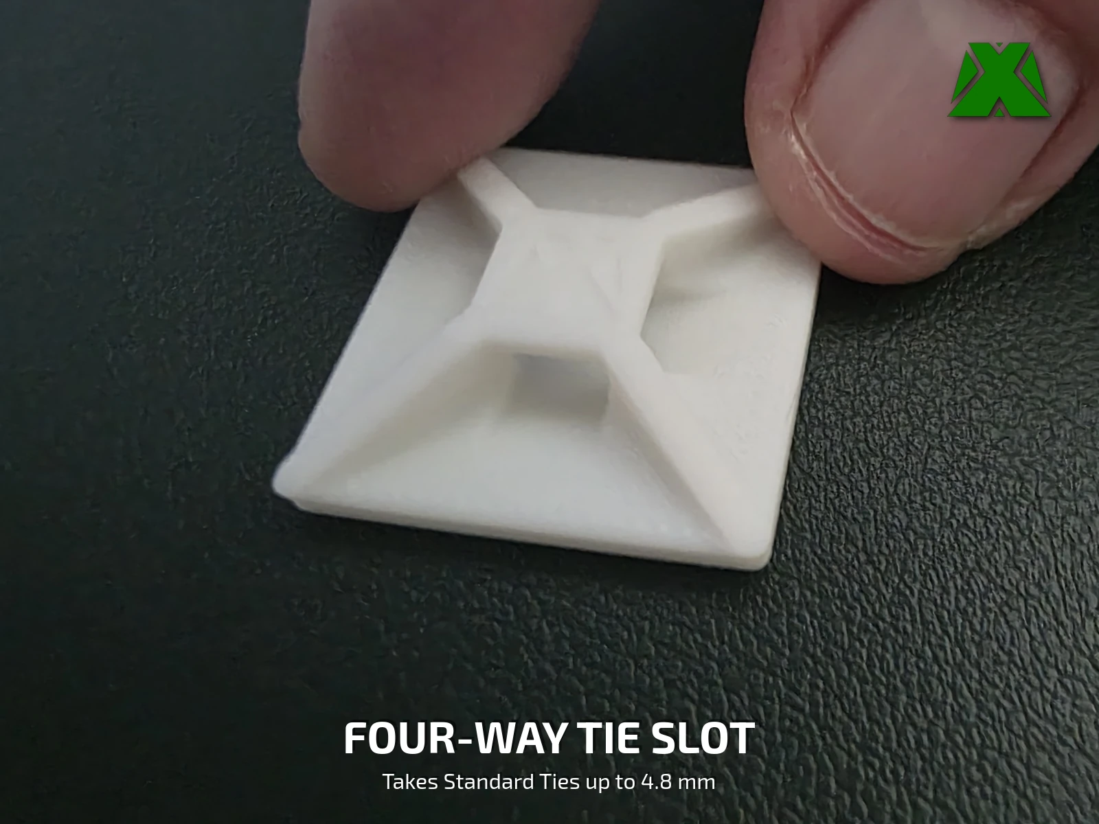 A white clip held in two fingers, showing the raised hub and the tie tunnel under it